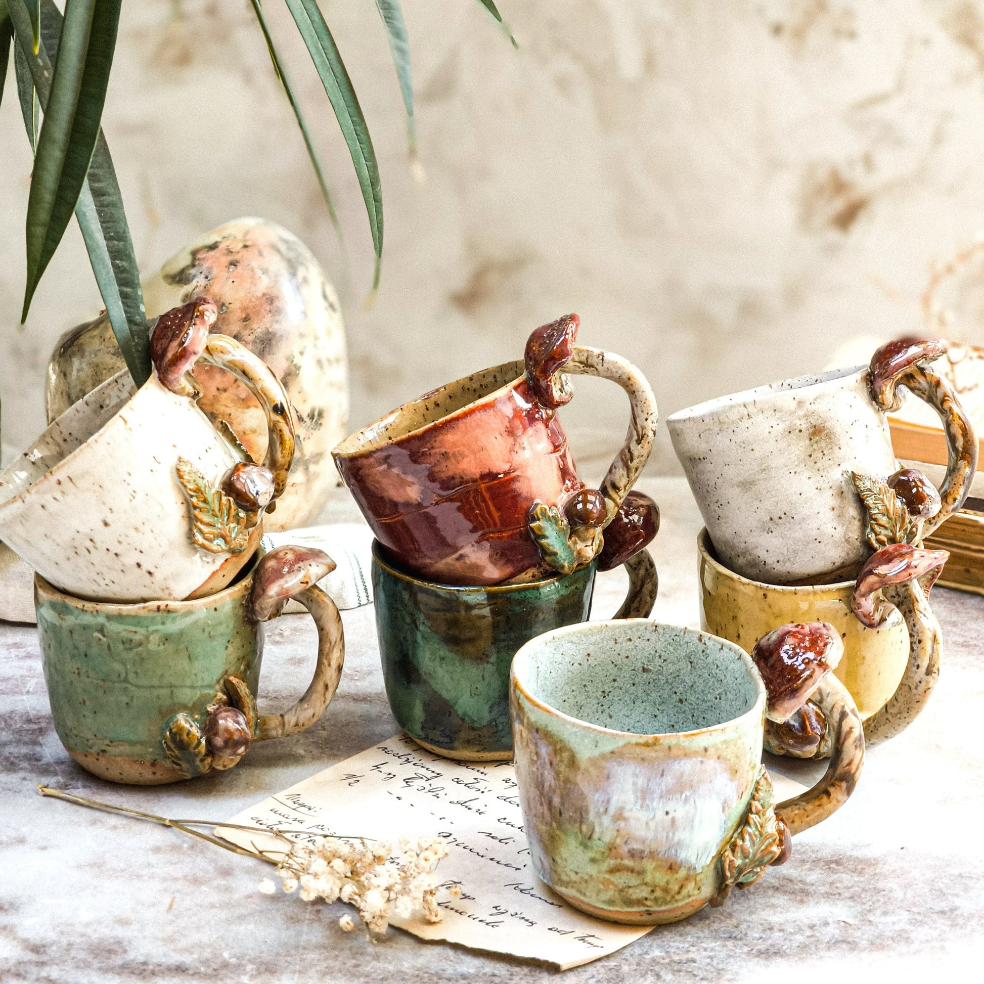 A group of handmade coffee cups with mushrooms sitting on top of a table.