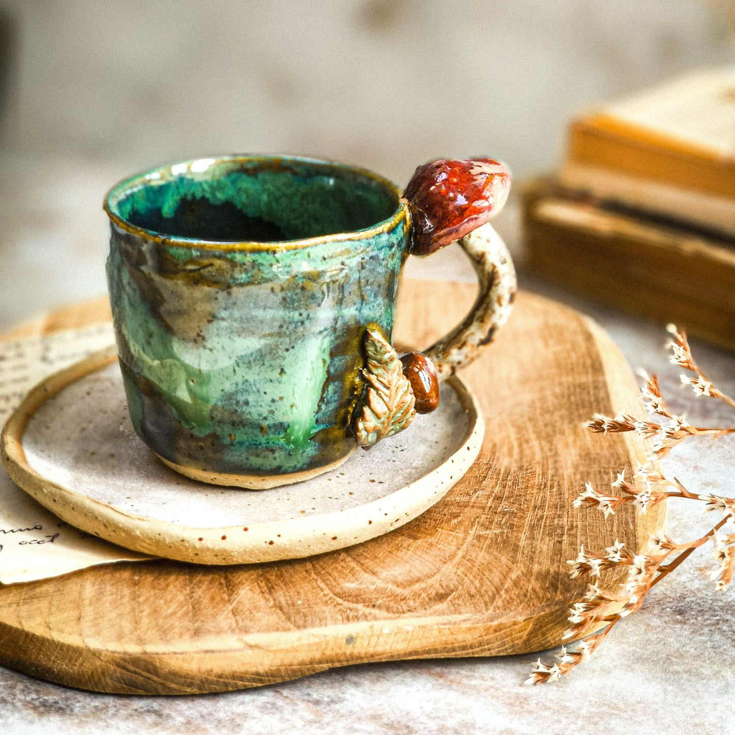 A tea or coffee cup in emerald green on a saucer plate in driftwood white